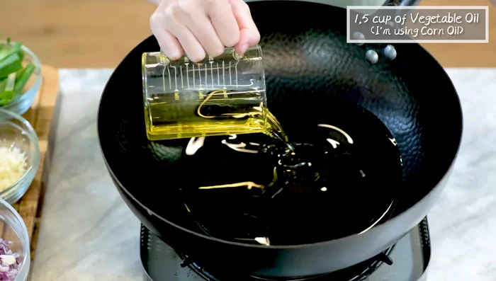 Heat oil in a wok over medium-low heat. Add onions and simmer for 5 minutes.