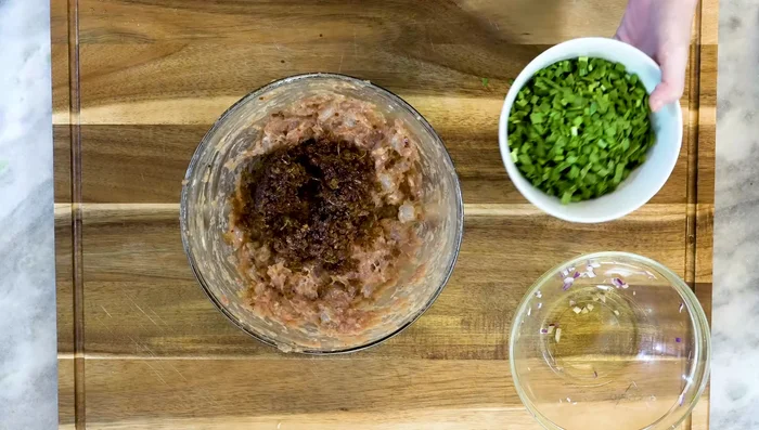 Add fried aromatics and garlic chives to the filling. Mix well.