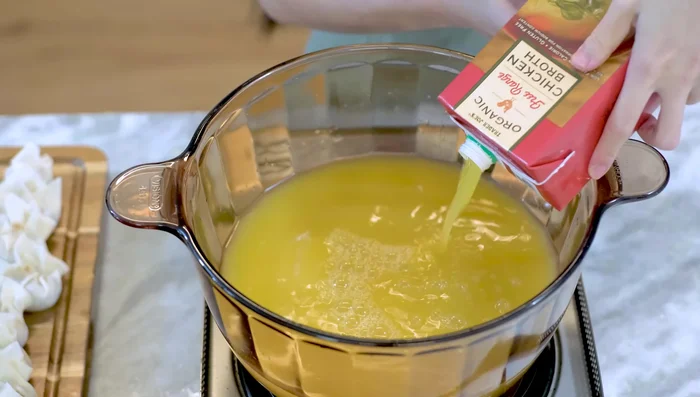 Bring chicken stock to a boil in a pot. Season with salt.