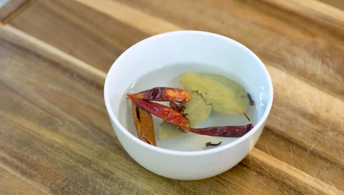 Soak spices (cinnamon, bay leaves, star anise, cloves, chilies) in hot water for 20 minutes.