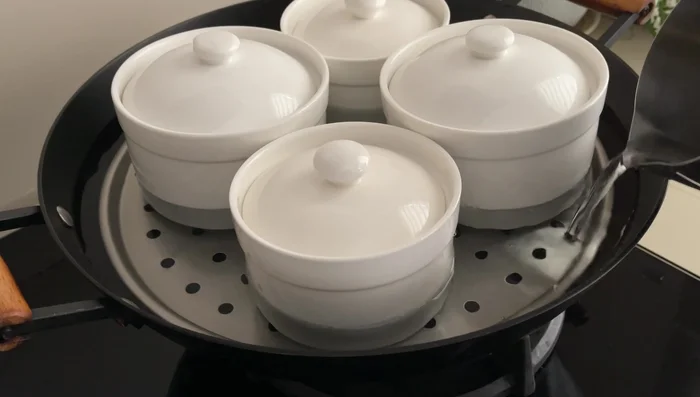 Cover the steamer and bring the water to a boil. Reduce heat to a simmer and cook for 2 hours, ensuring the water gently bubbles to prevent splashing.