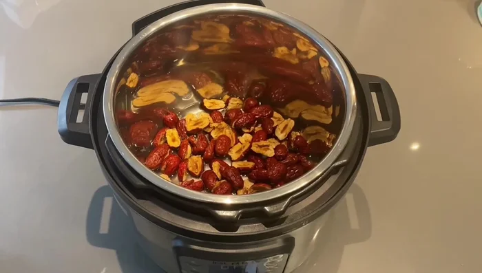 Add red dates and 500ml of water to the pressure cooker. Close the lid, set to high pressure for 10 minutes. Quick release when done. [63.8]