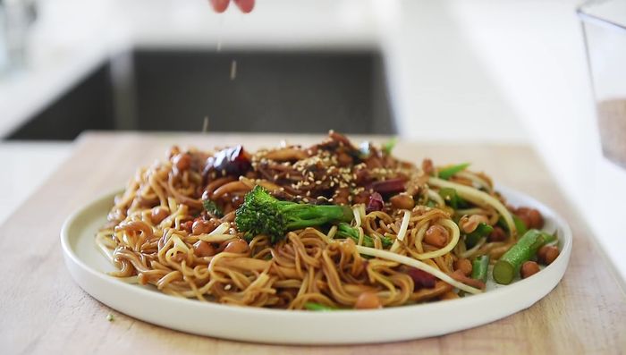 Plate the stir-fry and sprinkle with white sesame seeds.