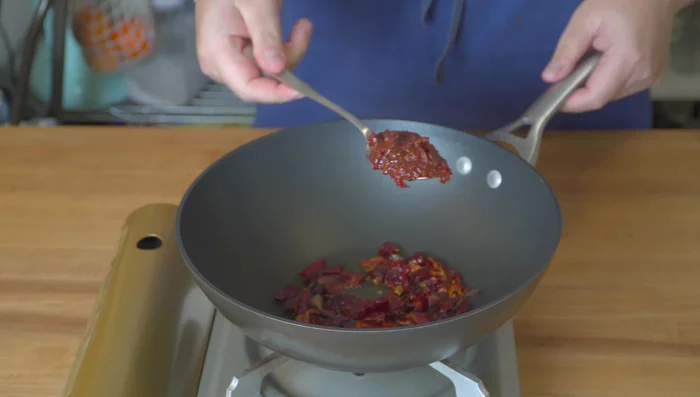 Braising and Reducing: Fry the chilies and Sichuan peppercorns until fragrant. Add aromatics and fried rabbit. Add orange peels, bay leaves, soy sauce, water, and sugar. Simmer on medium-low heat for about 15 minutes, stirring occasionally, until the liquid reduces and thickens.