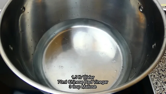 Prepare the boiling liquid by mixing water, Chinese red vinegar, and meltos. Bring to a boil.
