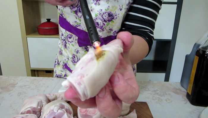 Prepare the pig's feet: Remove hair by burning with a lighter or using a cooker. Scrape off any blackened residue.