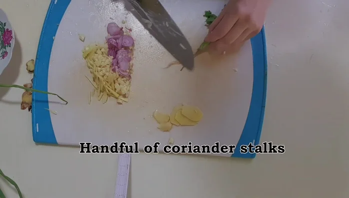 Shave off root hairs from coriander roots and keep the white part. Cut and separate the lower part of the coriander stock from the leaves. Cut away the roots of spring onions; cut the tops into 2-inch lengths and the bottoms into shorter lengths.