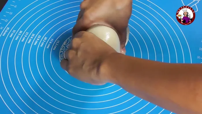 Roll the rested dough into a thick log, divide into 8 equal parts, and roll each into a smooth ball.