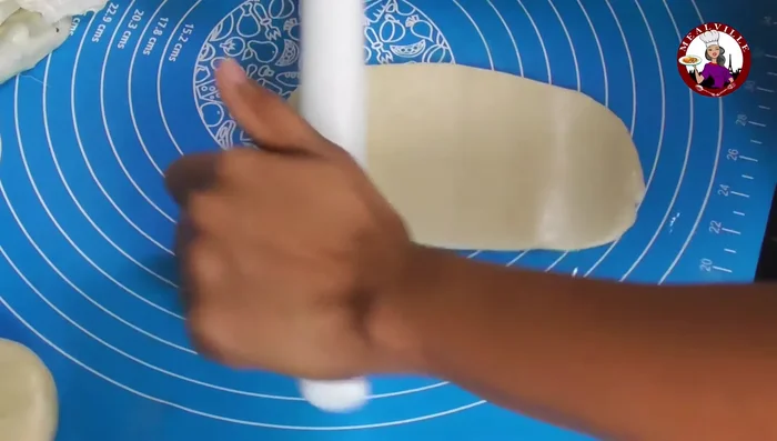 Oil your work surface. Flatten a dough ball, roll into a large rectangle, spread chopped onions evenly.