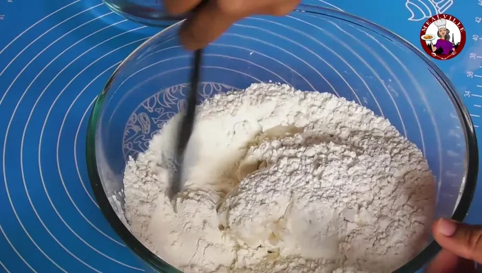 Gradually add boiling water, mixing with a spatula until a dough forms.
