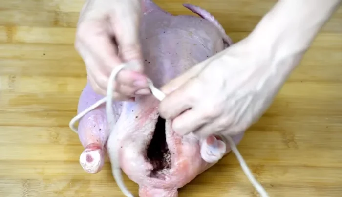 Truss the chicken: Use string or twine to truss the chicken tightly, preventing the wings from protruding.