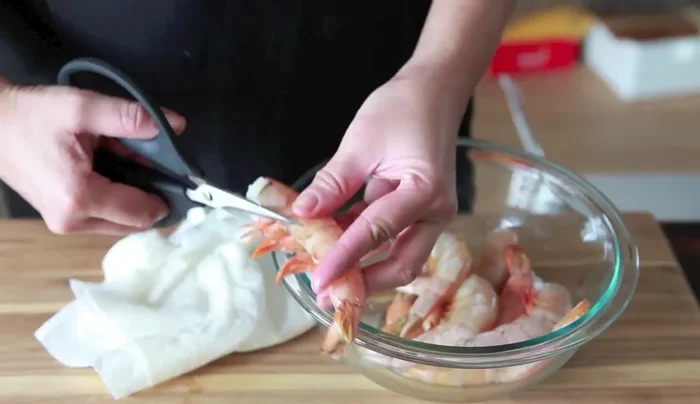 Prepare the shrimp: If using bamboo skewers, soak them in water for 30 minutes. If keeping the shell on, snip off the little feet. Remove the black vein (intestine) from the shrimp by cutting along the back or using a bamboo skewer.