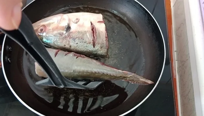 Add the mackerel pieces to the pan and sear both sides until slightly browned.(Timings are not specified in the transcript)