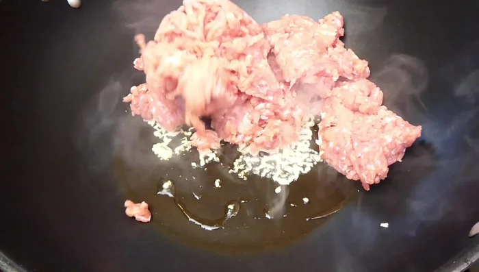 Add minced pork and break it down to cook until loosened.