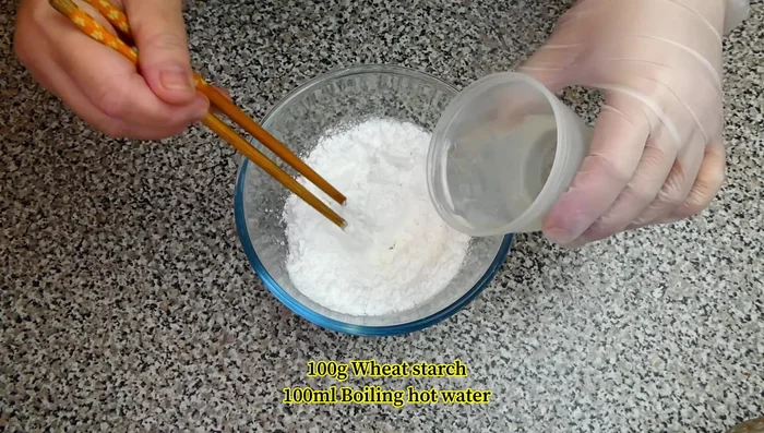 Prepare the wheat starch by gradually pouring in boiling hot water and mixing well. Transfer to a worktop and knead for about a minute until it forms a dough.