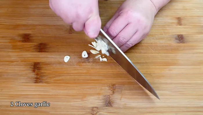While waiting, heat up the wok with oil and lightly sweat chopped garlic until fragrant.