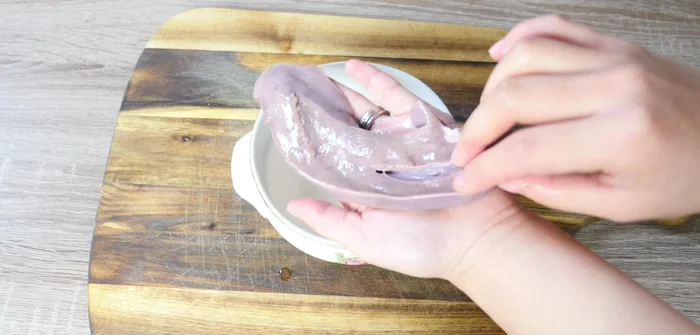 While the congee is cooking, prepare the pork liver. Cut it into smaller pieces and remove any white parts.