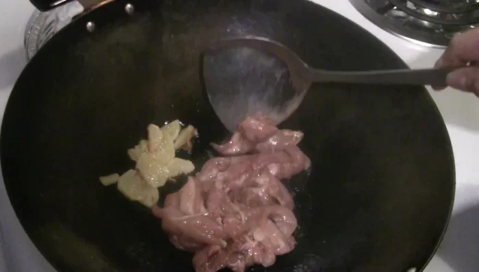 Add marinated chicken to the wok and stir-fry until almost cooked (90% cooked). Remove chicken and set aside.