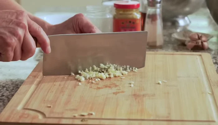 Prepare the garlic, ginger, and chili pepper by mincing the garlic (244.439), slicing the ginger into thin strips (254.959), and thinly slicing the chili pepper (279.72).