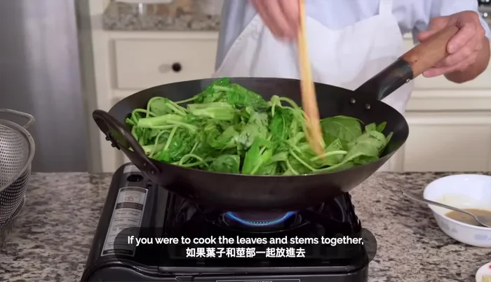 Blanch the water spinach stems for 30-40 seconds (544.959), then add the leaves and cook for another 2 minutes (591.839). Remove the blanched water spinach and place it in a colander to drain.