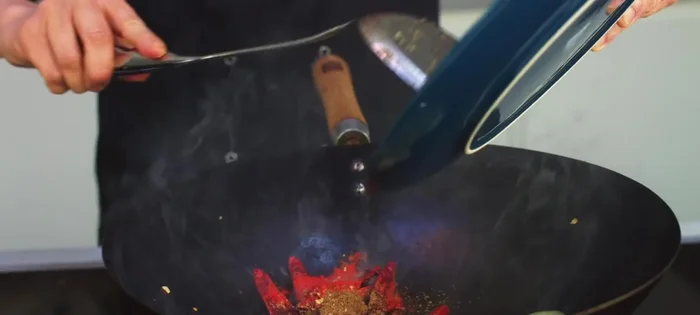 Deglaze and simmer: Add chicken stock and the reserved rice wine to the wok. Stir-fry until the sauce thickens slightly.