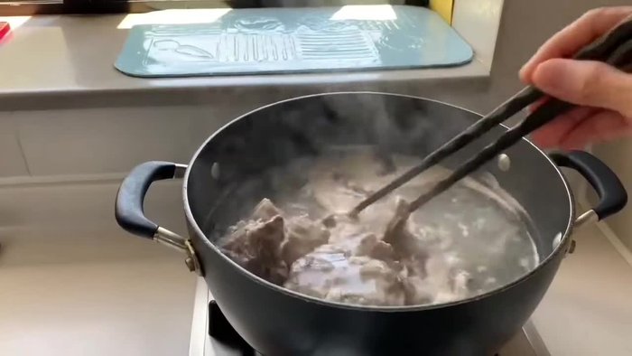 Blanch the pork bones in boiling water with a slice of ginger. This removes impurities and excess fat.