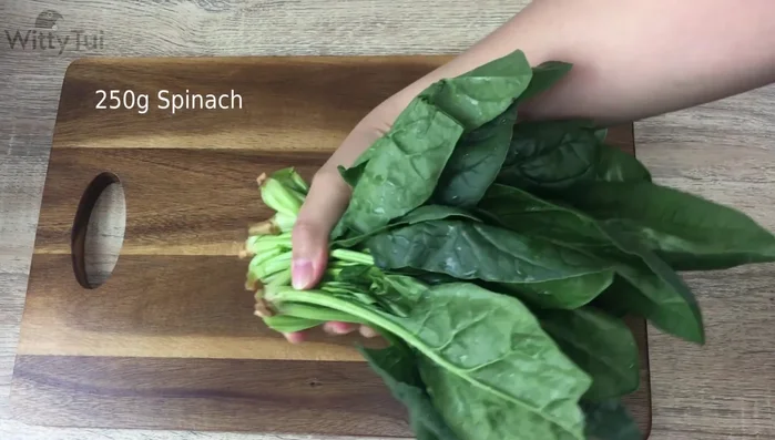 Wash and prepare 250 grams of spinach, cutting off the roots.