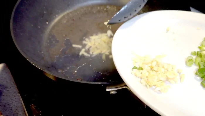 Add ginger and garlic to the pan and stir-fry for a brief moment.