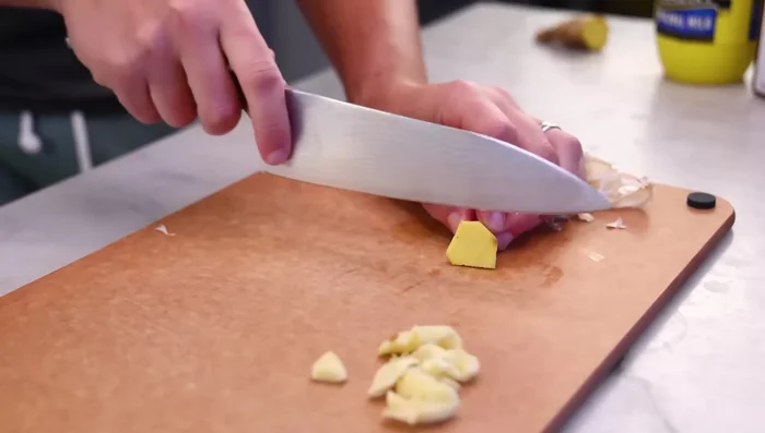 Prepare garlic sauce ingredients: Peel and finely chop garlic, ginger, and chili.