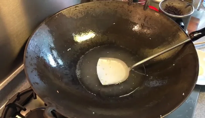 Add chicken stock, oyster sauce, sugar, and soy sauce to the wok. Simmer to create a sauce.