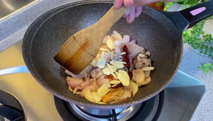 Add sliced garlic and spring onion stems. Mix and cook until onions become translucent.