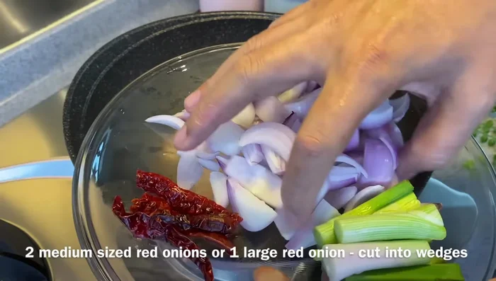 Add red onion and dried chili (if using). Fry for a minute or two until onions soften slightly.