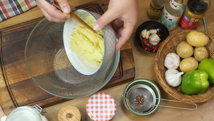Place potato shreds in a bowl. Pour boiling water over them, cover, and let sit for 10 minutes.