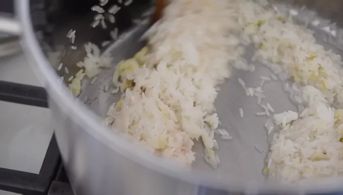 Add the rice and salt, sautéing for 3-4 minutes until it begins to stick to the pan.
