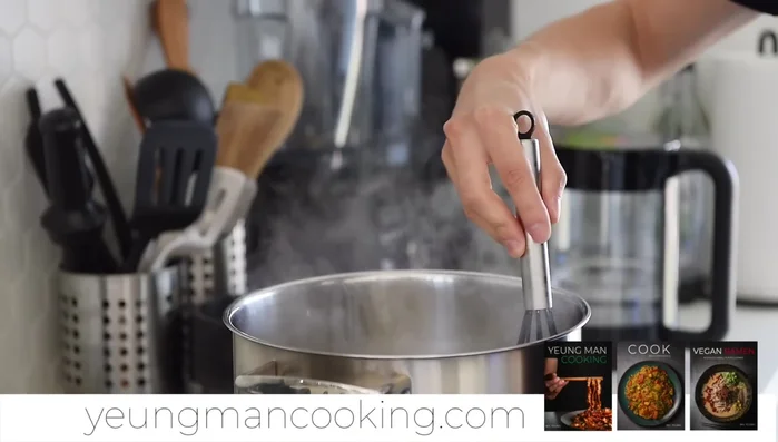 Gradually add the remaining hot water (7-8 cups), whisking constantly to break down the rice. Continue whisking for 4-5 minutes per addition of water.