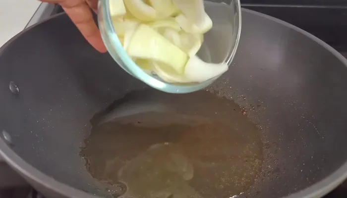 Add a few drops of sesame oil to the wok. Add onions, peppers, ginger, and garlic. Cook for about 5 minutes on medium-low heat until softened but still slightly crunchy.
