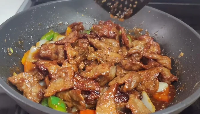 Return the cooked beef to the wok. Mix well to combine with the sauce.