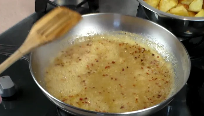 Add baked potatoes to the pan and toss to coat with the sauce.