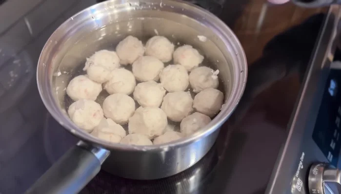 Bring the water to a simmer over medium-low heat, avoiding overcrowding the pot. Once simmering, gently jiggle the fish balls to prevent sticking and cook for 3-5 minutes until fully cooked and buoyant.