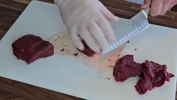 Slice the venison against the grain into very thin strips.