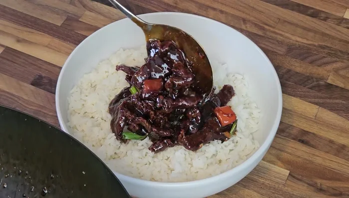 Serve the Mongolian venison over a bed of rice, garnished with sesame seeds.