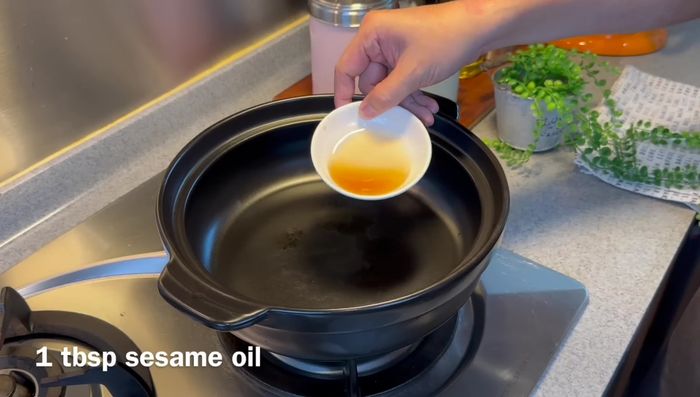 Heat sesame oil in a clay pot. Add sliced ginger and fry until fragrant.