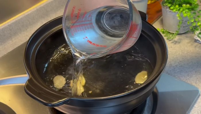 Add water, abalone brine, smashed coriander roots, oyster sauce, fish sauce, and chicken stock cube. Bring to a boil.