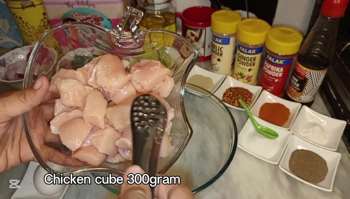 Cut boneless chicken into small cubes. Cut carrot, capsicum, onion, and cabbage into similarly sized cubes.