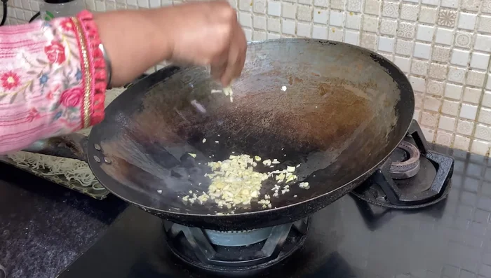 Add garlic and onions to the hot pan, sauté until fragrant.