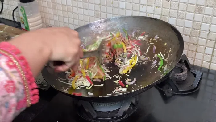 Add carrots and cabbage, tossing well to ensure even cooking and a smoky flavor.