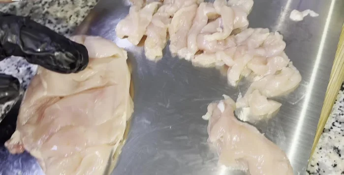 Prepare the chicken: Cut chicken into long pieces for fried rice and cubes for Manchurian. Marinate the cubed chicken with red chili sauce, ginger-garlic paste, corn flour, red chili, black pepper, white vinegar, soy sauce, salt, and cumin powder. Let it marinate for at least 30 minutes.