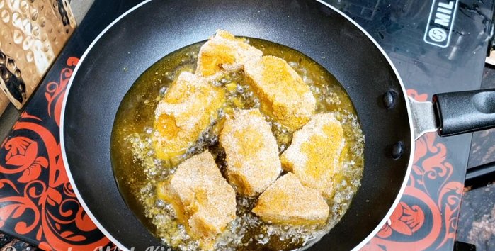 Heat oil in a pan and fry the marinated fish pieces on low flame until golden brown. Avoid high flame to prevent burning.