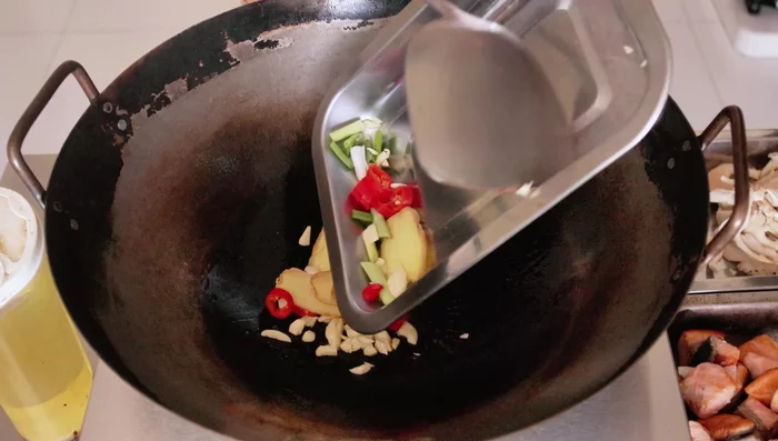 Stir-fry ginger, garlic, chili, and white parts of spring onions for about a minute.