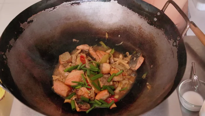 Add the green parts of the spring onions and mix well. Turn off the heat.